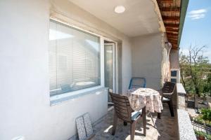 balkon ze stołem i krzesłami oraz oknem w obiekcie New Apartment in quiet area no 1 w mieście Bitola