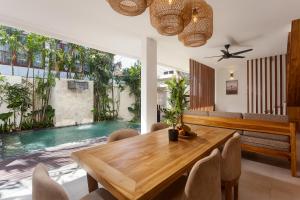 a dining room with a table and chairs and a pool at The Arca Villas by GenuineHost in Sanur