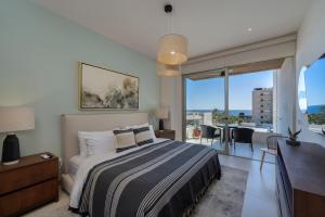 a bedroom with a bed and a balcony with a view at Luxury Beachfront Apartment in Cabo in Cabo San Lucas +51 photos