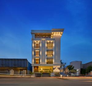 a tall white building with lights on it at Grand Continent Mysore A Sarovar Portico Affiliate Hotel in Mysore