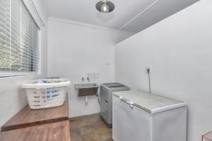 a white kitchen with a sink and a refrigerator at Potties House in Arniston in Arniston +37 photos