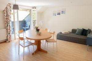 ein Wohnzimmer mit Tisch, Stühlen und Sofa in der Unterkunft BnB Ilfis Wohnung Nr 1 in Langnau im Emmental + 16 Fotos