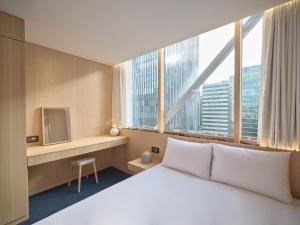 a hotel room with a bed and a large window at UH Suite The Gangnam in Seoul