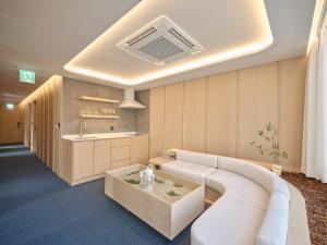 a living room with a white couch and a table at UH Suite The Gangnam in Seoul