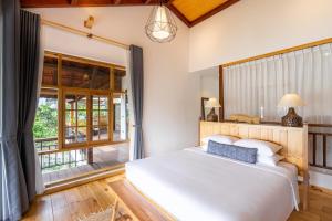 Un dormitorio con una cama y una ventana grande. en Man Villa -sunset Outdoor Jacuzzi 8min To Oldtown, en Hoi An