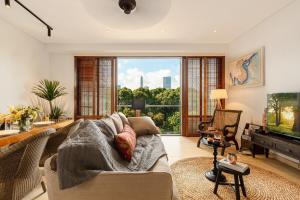 a living room with a couch and a tv at De Old Sport - Vesta Collections in Ho Chi Minh City