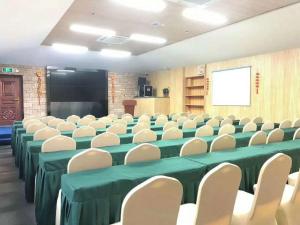 南京美豪丽致酒店（南京仙林大学城金鹰店）的一个带椅子和屏幕的会议室