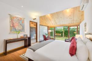 una camera da letto con un grande letto bianco e una scrivania di Villa De Exotica - Vesta Collections a Hoi An Altre 79 foto