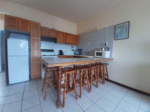 a kitchen with wooden cabinets and a counter with bar stools at Unit 606 Seabrook in Margate +10 photos