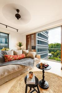 a living room with a couch and a large window at De Old Sport - Vesta Collections in Ho Chi Minh City