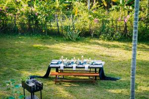 a table with glasses on it in a yard at Bong Villa Hoi An - Vesta Collections in Hoi An