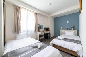 Giường trong phòng chung tại Plaza In Miyakojima hotel