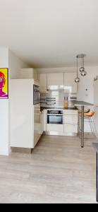 a kitchen with white appliances and a table in it at Ruhige komplette Wohnung voll Ausgestattet 35min Bahn bis München in Reichertshausen