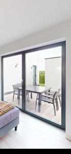 a living room with a table and a glass window at Ruhige komplette Wohnung voll Ausgestattet 35min Bahn bis München in Reichertshausen +2 photos