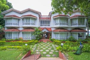 a large house with a garden in front of it at The Gateway Hotel Pasumalai Madurai in Madurai