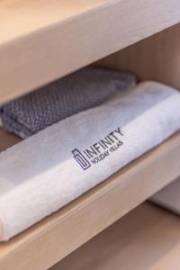 a stack of towels on a shelf at Infinity Holiday Villas - Private Pool, close to Kalamaki Centre, by ZanteWize in Kalamaki +54 photos