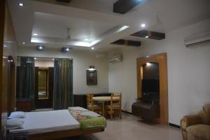 a bedroom with a bed and a table and a chair at Hotel Naveen Residency in Darbhanga