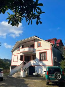a white house with a staircase leading up to it at Home in paradise in Tofaloglebi