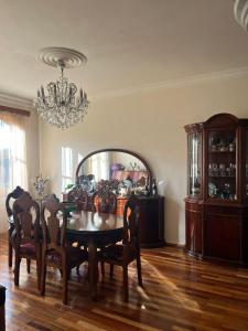 a dining room with a table and chairs and a chandelier at Home in paradise in Tofaloglebi
