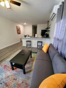 ein Wohnzimmer mit Sofa und Tisch in der Unterkunft Lakewoodlyon Park Renovated Cottage Near Duke 28a in Durham