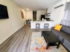 a living room with a couch and a table at Lakewoodlyon Park Renovated Cottage Near Duke 26b in Durham +4 photos