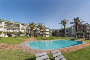 a swimming pool in front of a apartment complex at Brookes Hill 1 Bedroom in Summerstrand