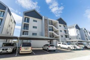 een parkeerplaats met auto's geparkeerd voor een gebouw bij Bella Retreat Bellamare in Summerstrand +36 foto's
