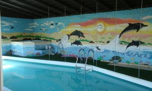 a swimming pool with a mural of dolphins at Heidi Haus in Port Alfred