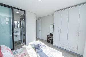 a bedroom with white cabinets and a bed and a desk at Bella Protea - 2 Bedroom in Summerstrand +47 photos