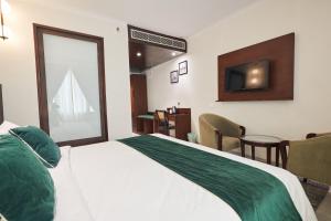 Postel nebo postele na pokoji v ubytování Deventure Sarovar Portico Patel Nagar