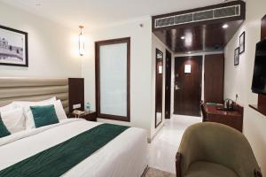 Postel nebo postele na pokoji v ubytování Deventure Sarovar Portico Patel Nagar