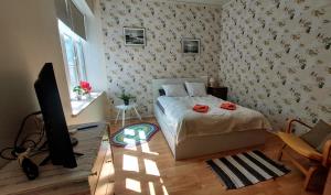 a bedroom with a bed and a flat screen tv at Posti 19 Apartment in Haapsalu