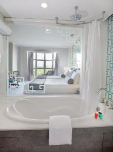 a white bath tub sitting next to a white sink at Dorsett Shanghai in Shanghai