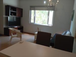 a living room with a table and chairs and a television at Tiny Little SUITE in Athens