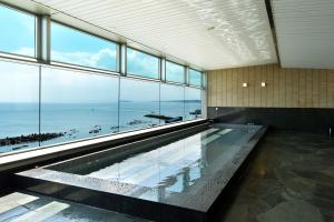 a large swimming pool with a view of the ocean at Hayama Umino Hotel in Hayama