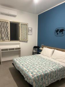 a bedroom with a bed and a blue wall at SummerHouse in Mazzeo +27 photos