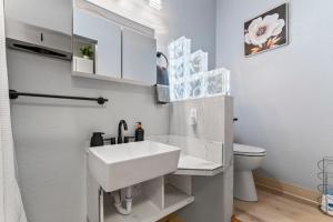 a white bathroom with a sink and a toilet at Stylish Studio Suite Near Downtown in Anchorage +4 photos