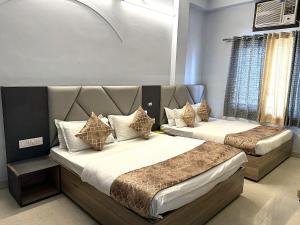 a bedroom with two beds in a room at Hotel City Palace in Varanasi