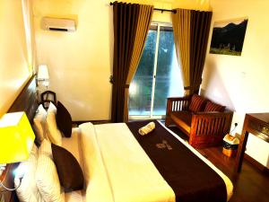a bedroom with a bed and a chair and a window at Wintry Hills-Nuwara Eliya in Nuwara Eliya