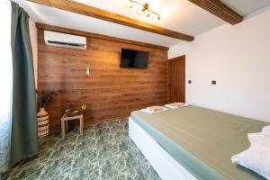 a bedroom with a bed and a tv on a wall at Бунгало Есмералда in Aheloy +55 photos