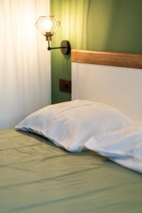 a bed with a white pillow and a lamp at Бунгало Есмералда in Aheloy