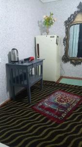 a desk and a refrigerator in a room at hotel for decent people in Tashkent