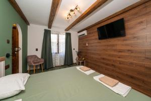 a bedroom with a wooden wall with a flat screen tv at Бунгало Есмералда in Aheloy