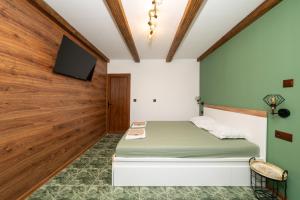 a bedroom with a bed and a flat screen tv at Бунгало Есмералда in Aheloy