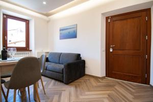 a living room with a chair and a table at Finestra Sul Borgo in Trevignano Romano