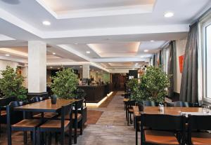 een restaurant met tafels en stoelen en een bar bij Relais de la Sarvaz in Saillon