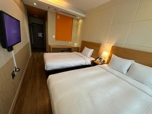 una camera d'albergo con due letti e una TV a schermo piatto di Hotel Icc a Daejeon