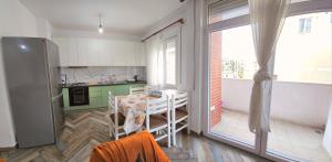 a small kitchen with a table and a refrigerator at Daily Apartment 3 in Tirana