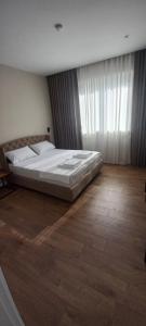 a large bed in a bedroom with a wooden floor at Vila BABE in Vlorë +66 photos