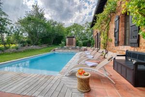 a swimming pool with lounge chairs next to a house at Montillet - Maison piscine terrain multisport in Belbèze-de-Lauragais